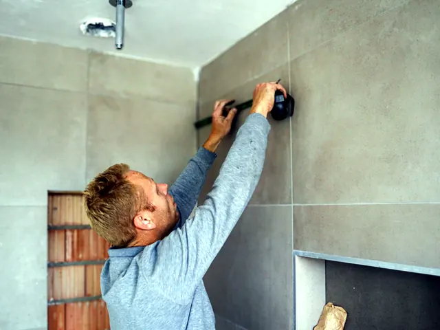 Monteur tekent een maat af op een tegelwand in een badkamer in aanbouw